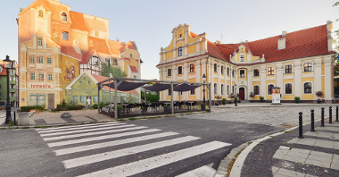 Najpopularniejsze budynki na Śródce. Po lewej mural, którzy przedstawia włoską uliczkę.