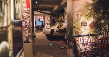 Część ekspozycji muzealnej Poznańskiego Czerwca 1956. W centrum widać część czołgu. Dookoła na ścianach wiszą zdjęcia uczestników strajku. W tle ekran telewizora, na którym wyświetlone jest przemówienie Stanisława Matyi z uroczystości odsłonięcia pomnika "Jedność".
