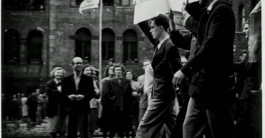 Widok z boku na pochód robotników. Na czele Janusz Kulas (pierwszy) z innymi dwoma mężczyznami niesie transparent "Żądamy chleba".