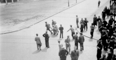 Ulica Kochanowskiego 28 czerwca 1956 roku około godziny 12.30. Ludzie niosą do szpitala ranną kobietę.